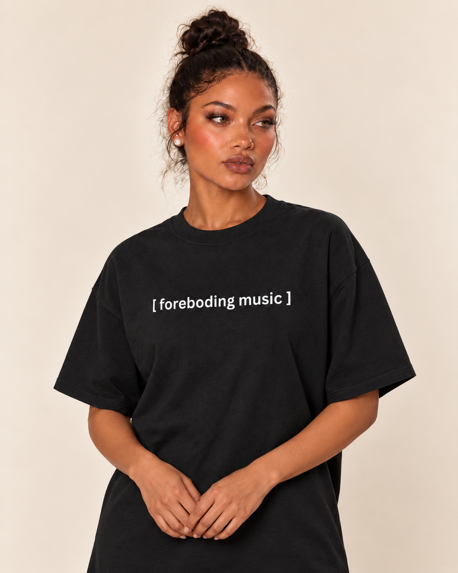 [Closed Captions] Foreboding Music - Unisex Oversized Boxy Tee — Black, existing Treattees model in varied standing pose, faithful print and close crop